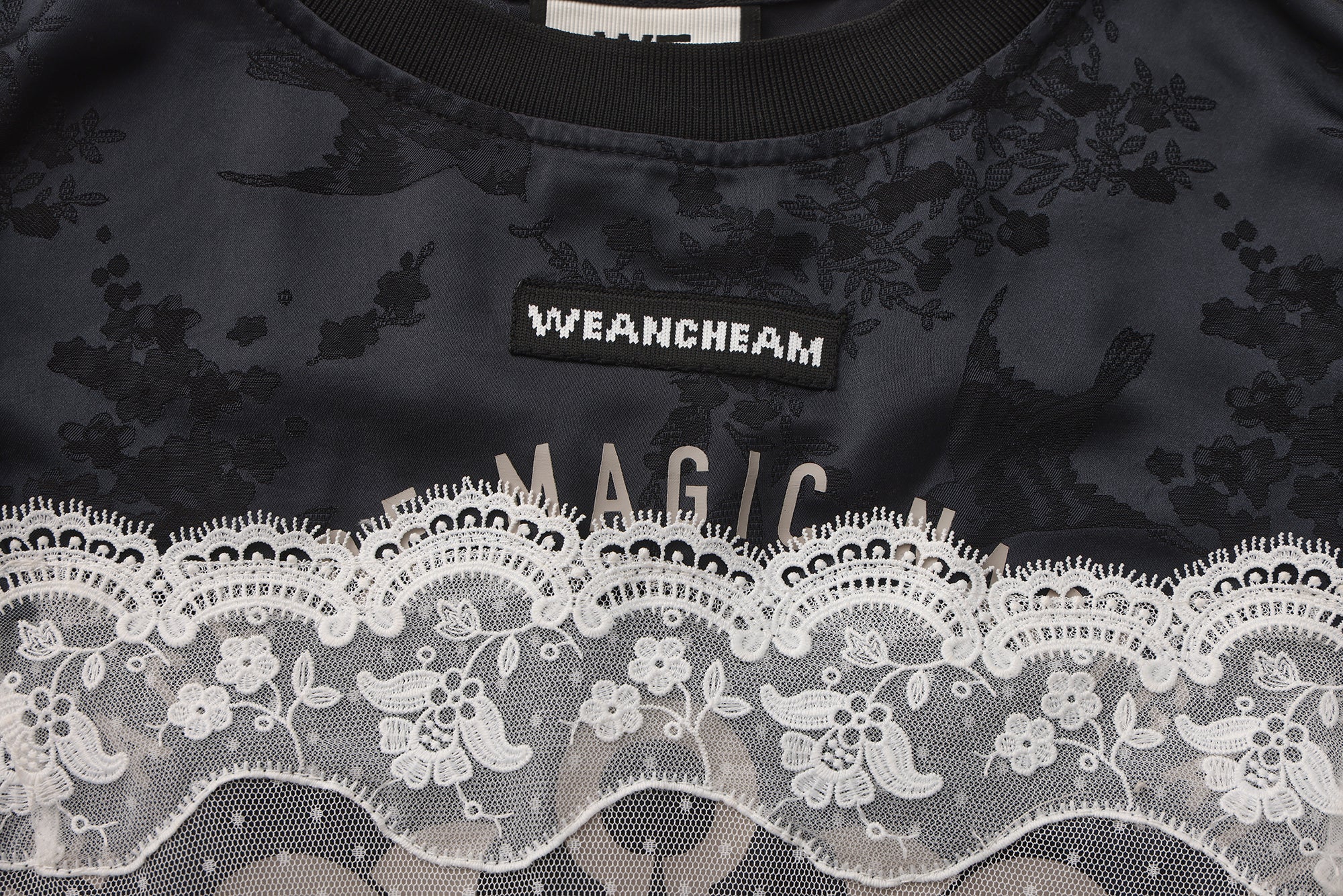 Close-up of detachable mesh sleeve and lace trim detail on satin sports dress