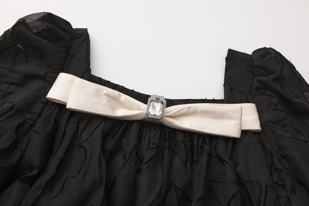 Close-up of ruffled layers and silky fabric texture on bubble sleeve dress