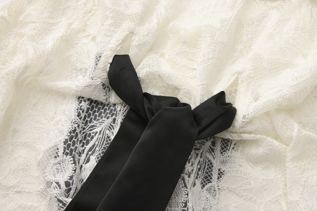 Close-up of bow tie neckline and 3D floral lace details on tulle dress
