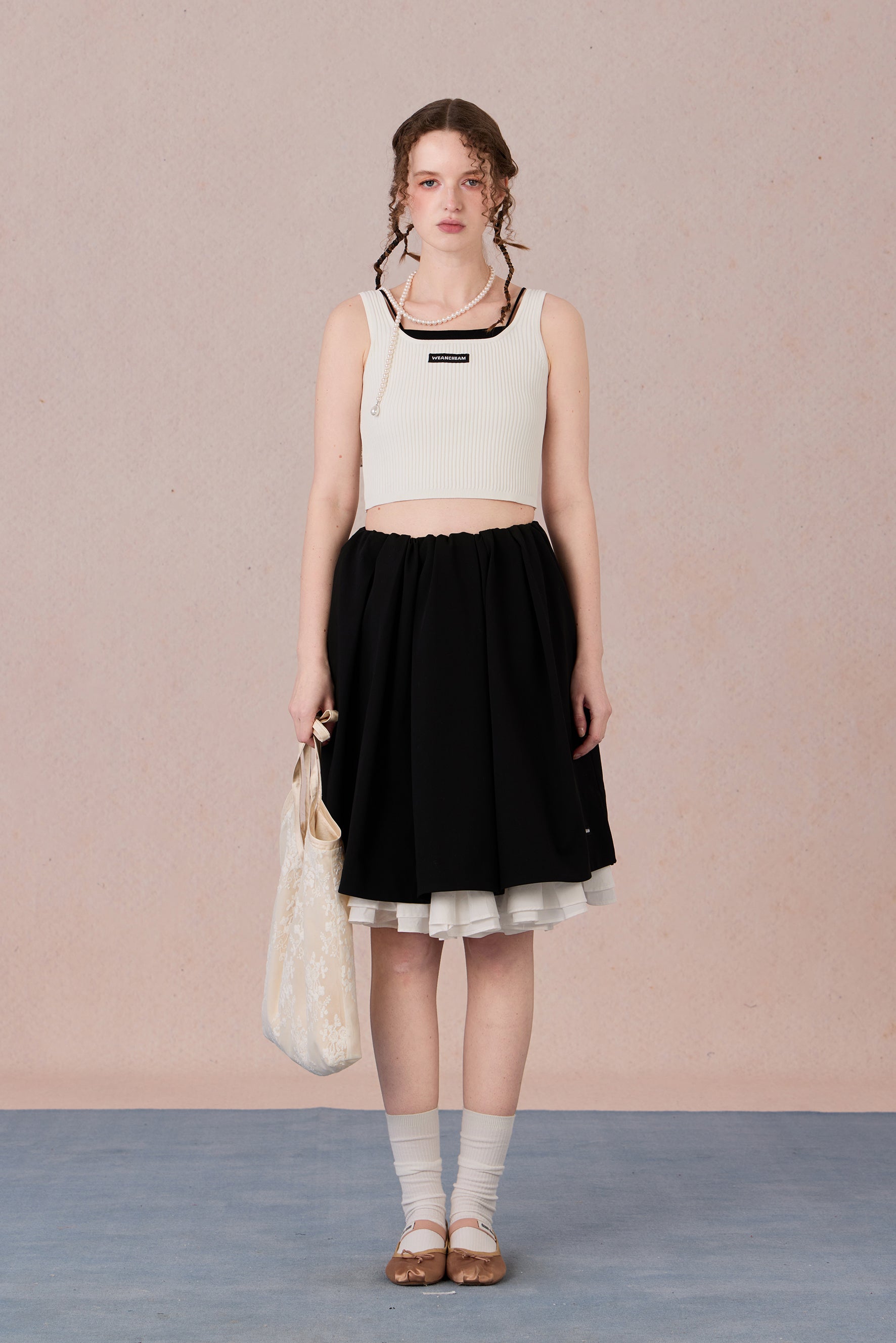 Sleeveless black and white layering-effect tank styled under a blazer