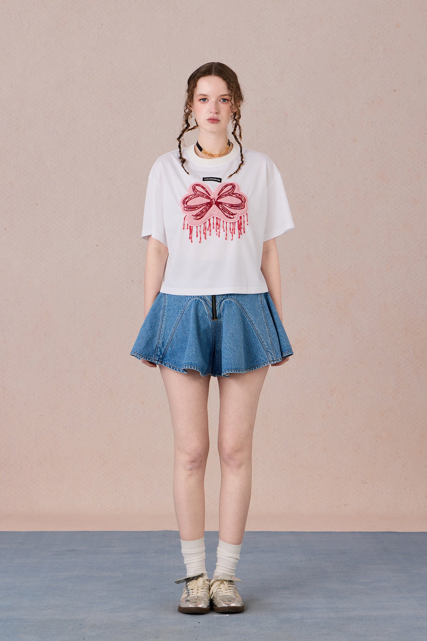 Loose fit round neck tee with bold red hand-beaded bow design