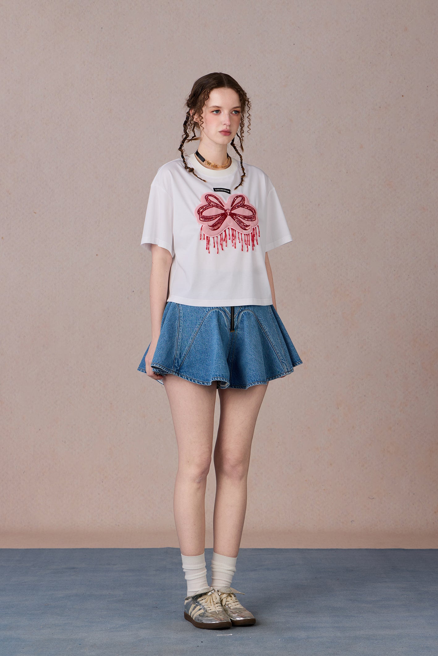 Loose fit round neck tee with bold red hand-beaded bow design