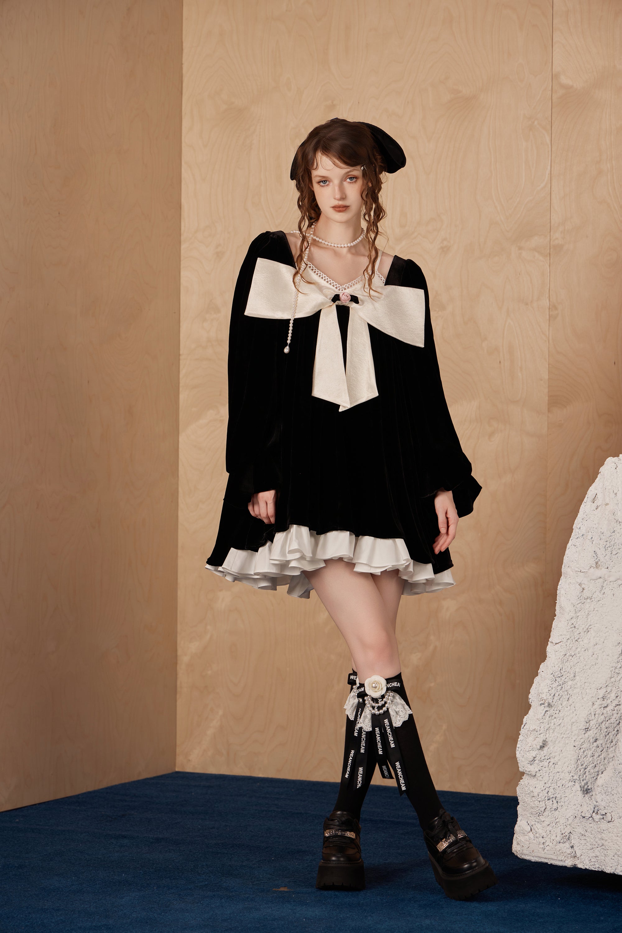 Model wearing elegant layered two-piece dress with sculptural bow