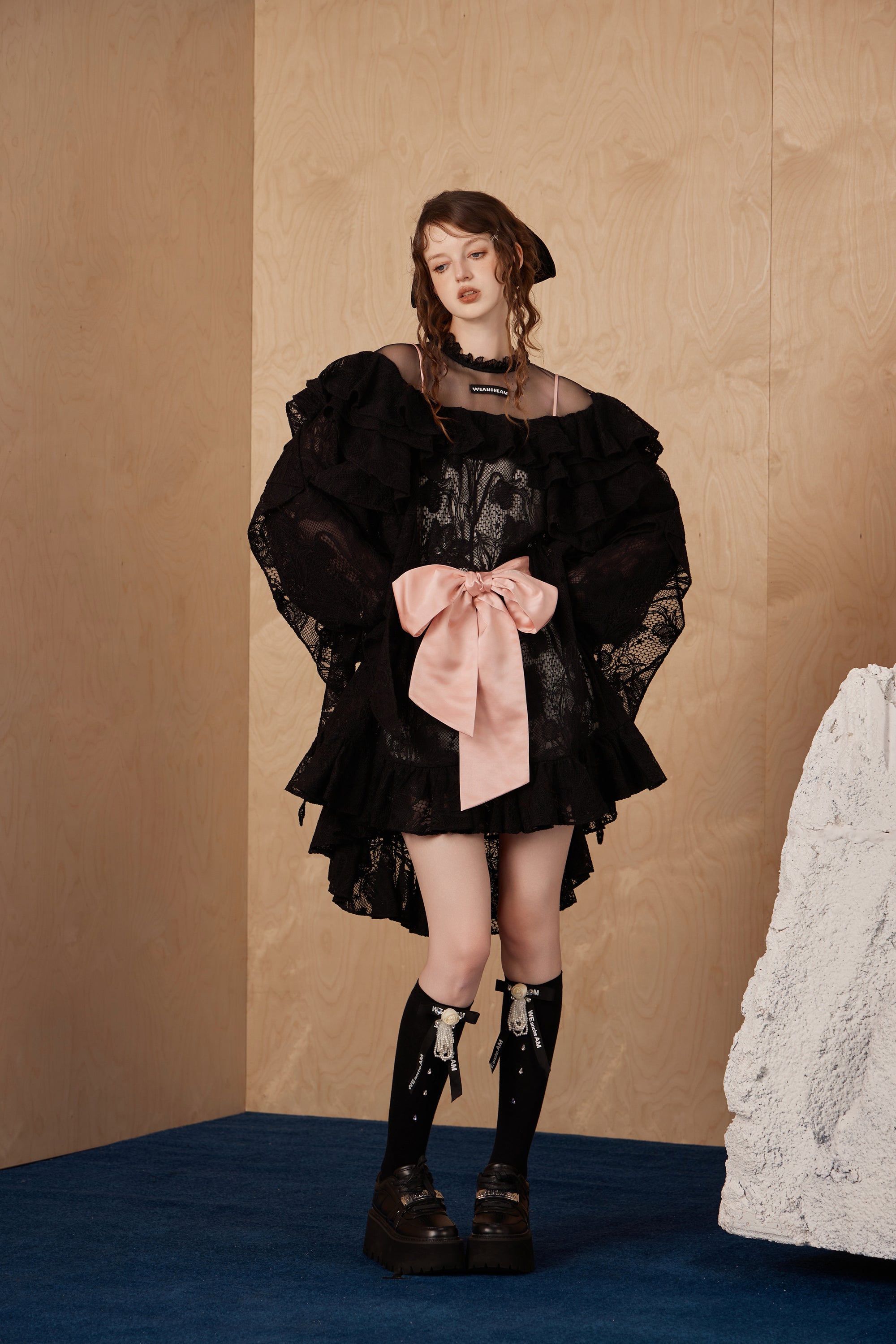 Model wearing lace bow tie dress with layered tulle and fairycore elegance