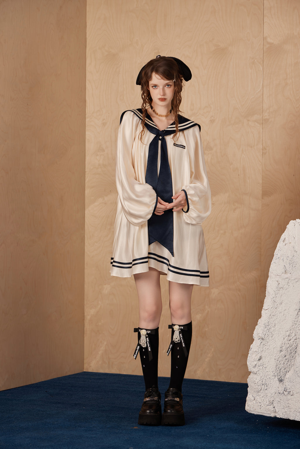 Model wearing elegant navy collar ribbon dress with flowing A-line hem