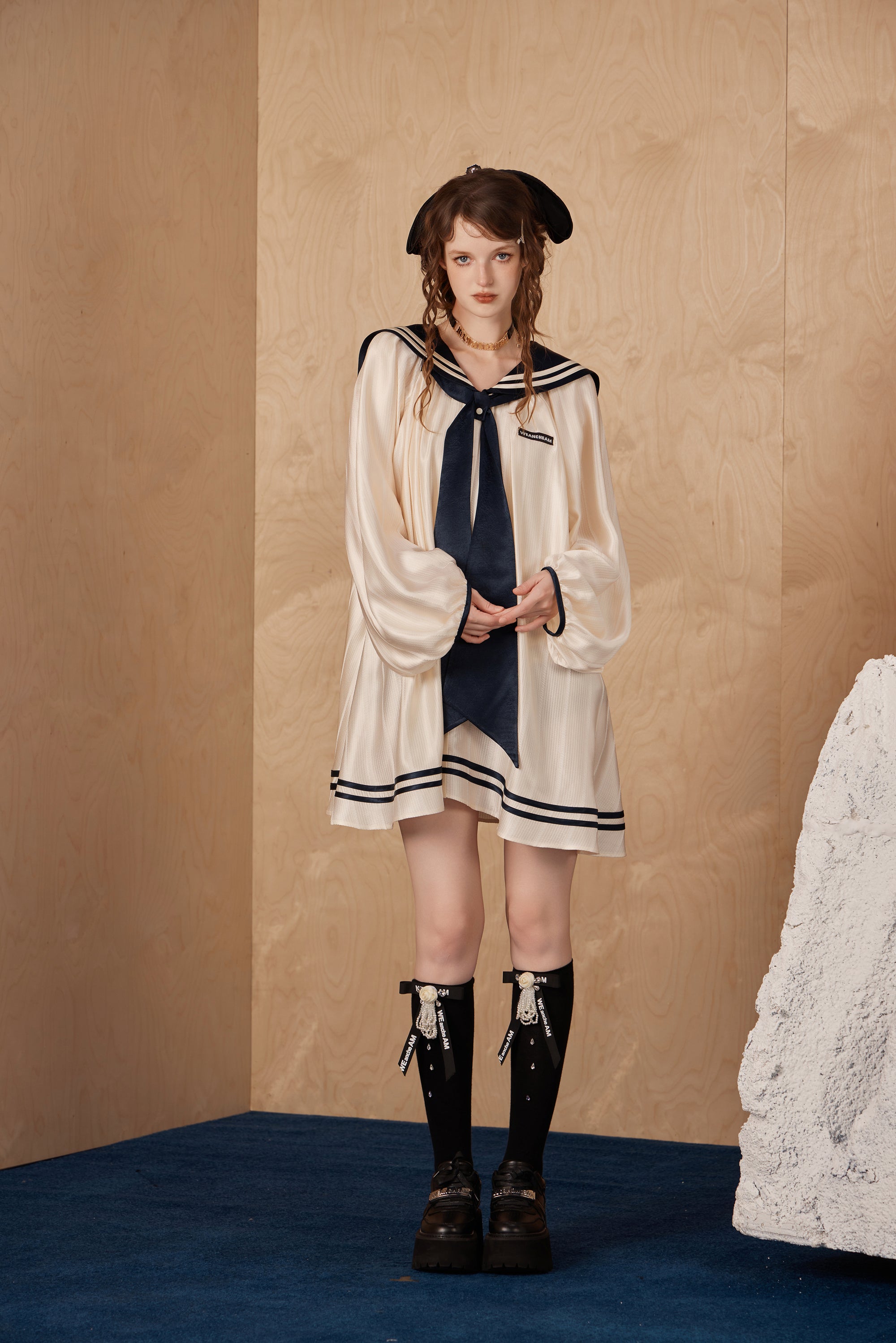 Model wearing elegant navy collar ribbon dress with flowing A-line hem