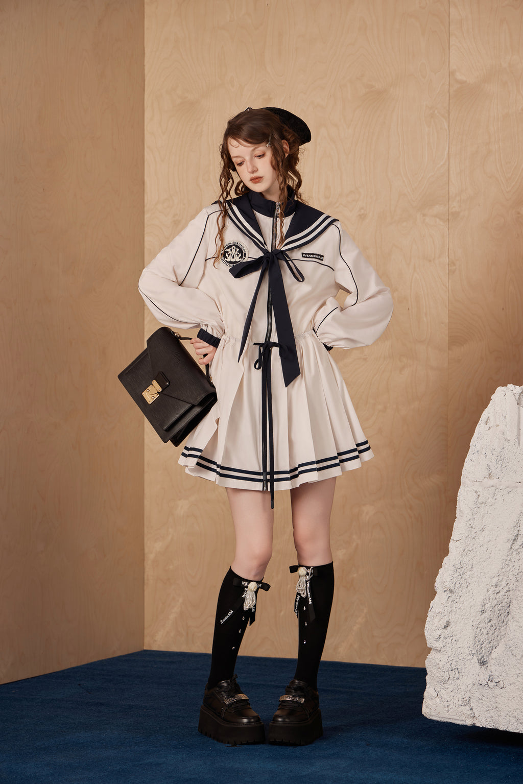 Model wearing navy collar nylon sports jacket dress with wide collar and waist detail