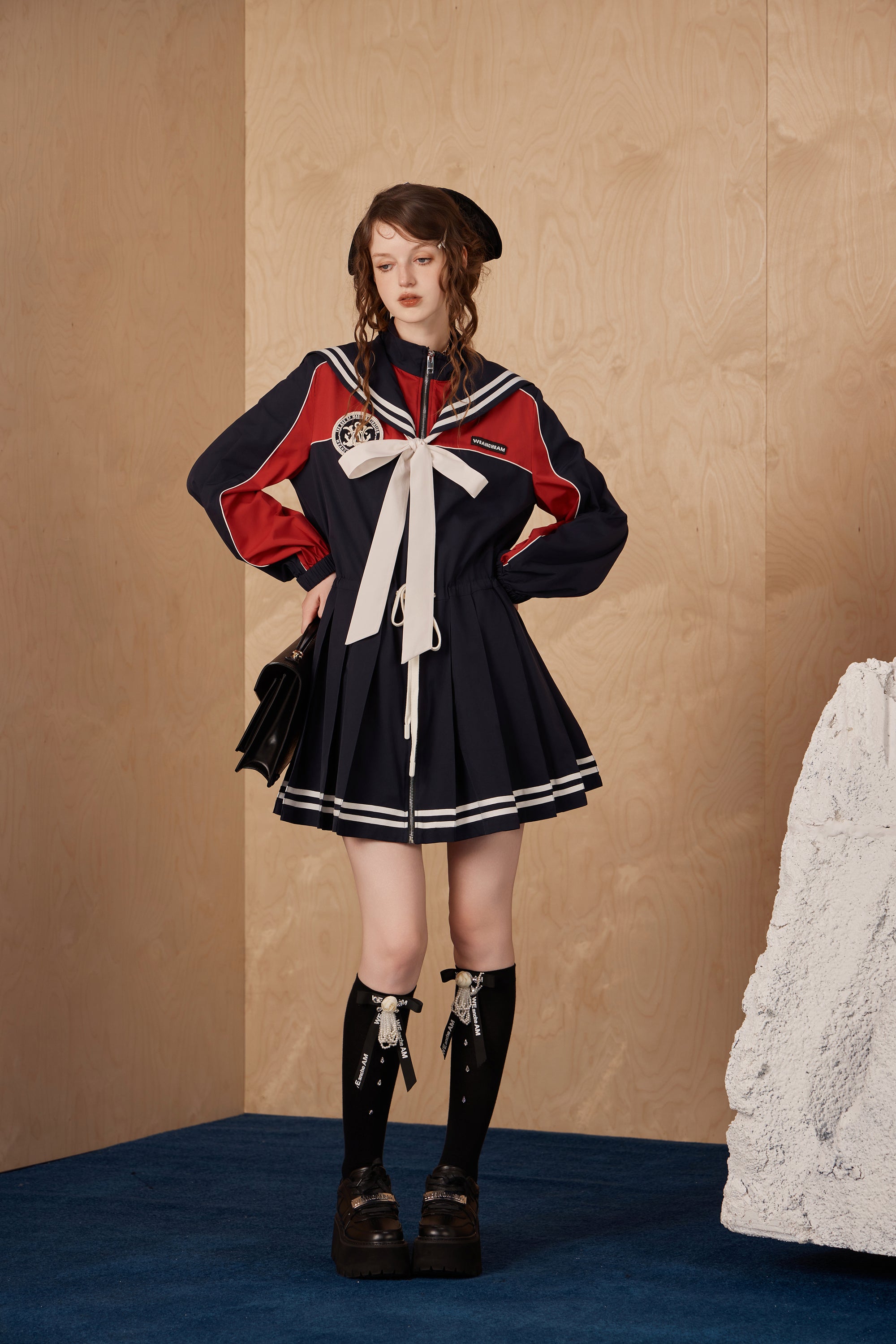 Model wearing navy collar nylon sports jacket dress with wide collar and waist detail