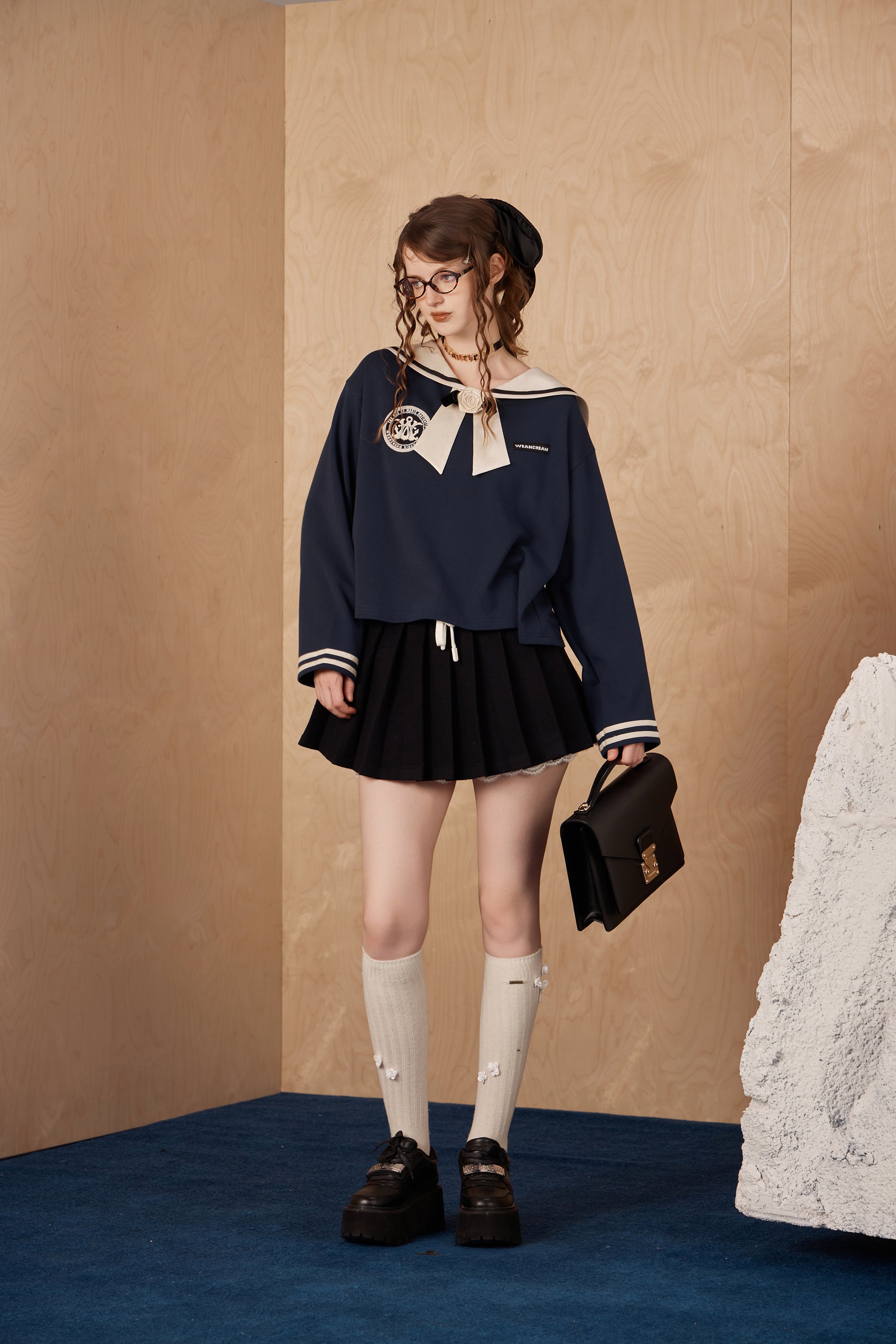 Model wearing collegiate navy T-shirt with satin collar and hand-sewn silk flowers