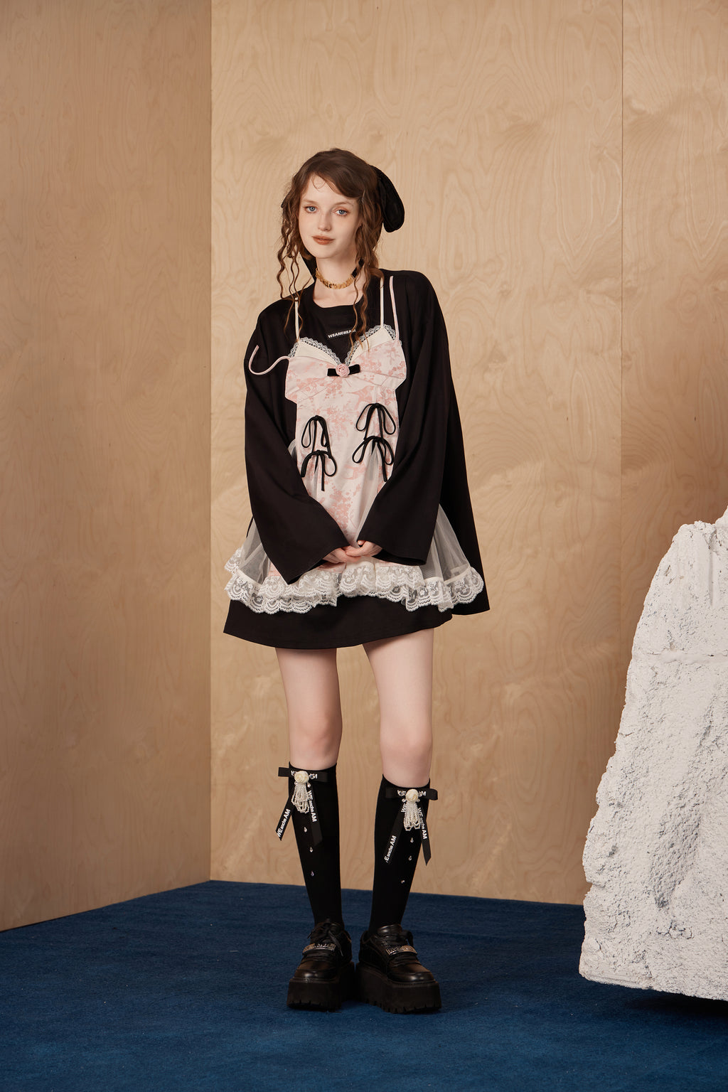 Model wearing faux two-piece bow long-sleeve T-shirt with cascading bows