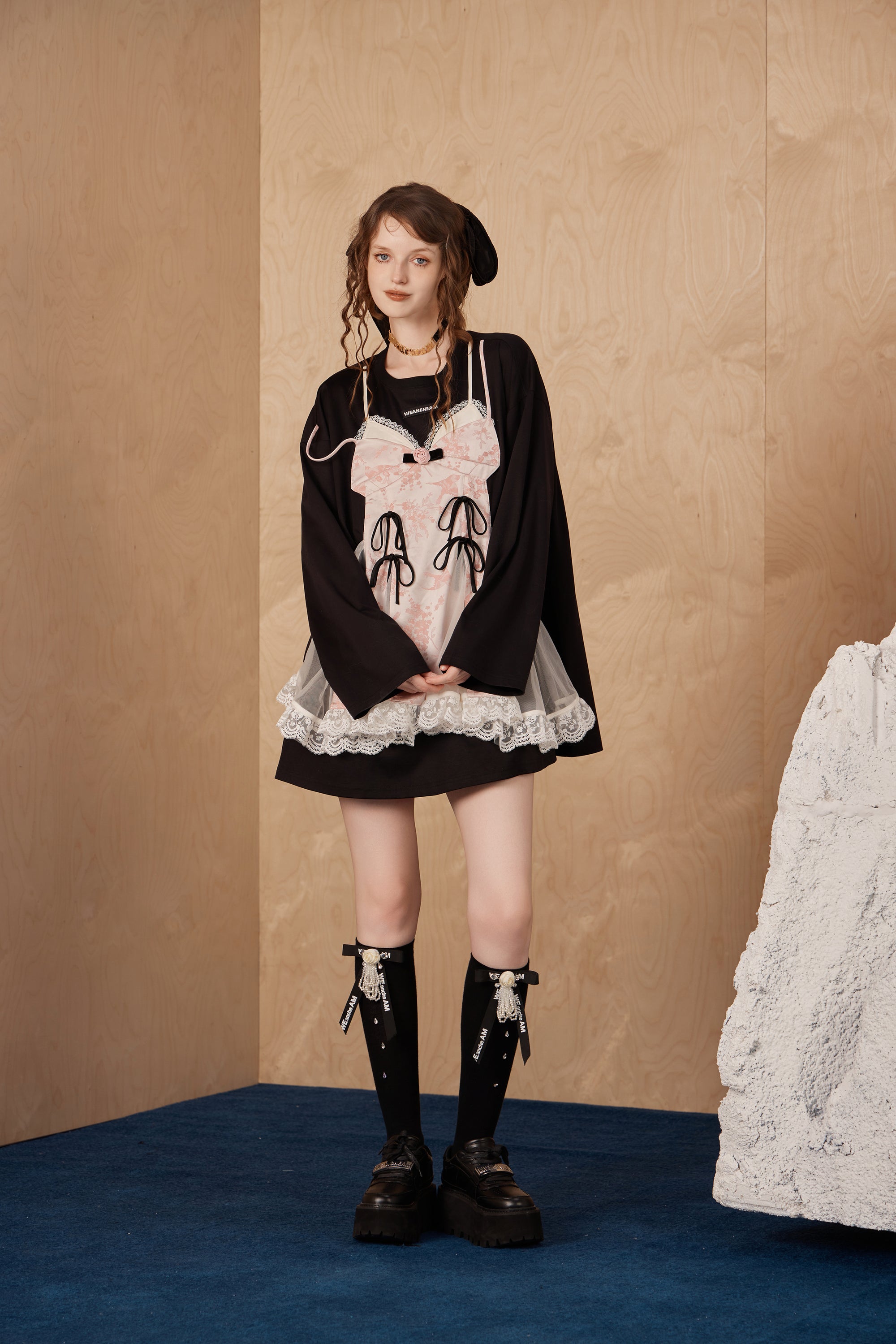 Model wearing faux two-piece bow long-sleeve T-shirt with cascading bows