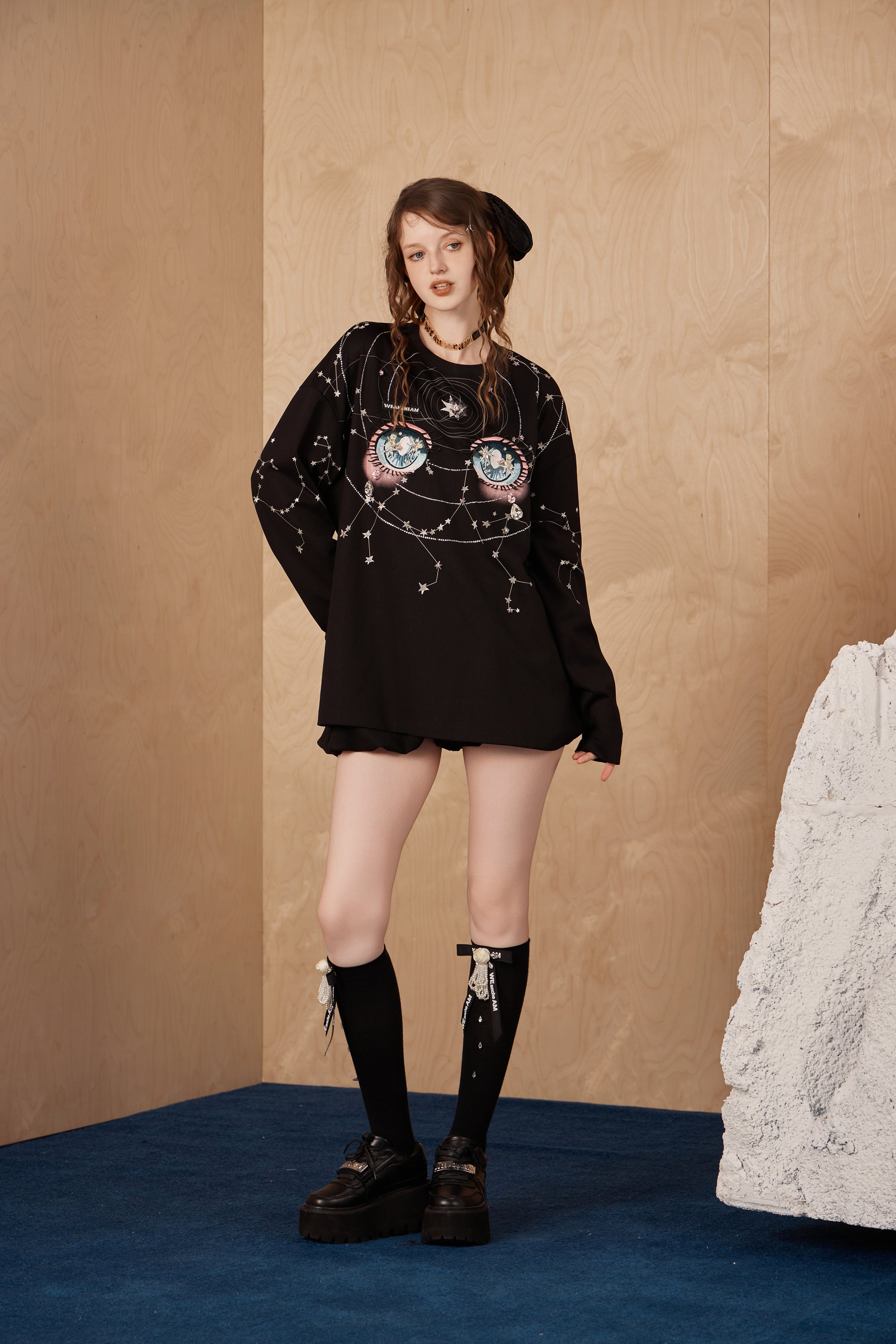 Model wearing constellation-inspired rhinestone long-sleeve T-shirt with embroidered label