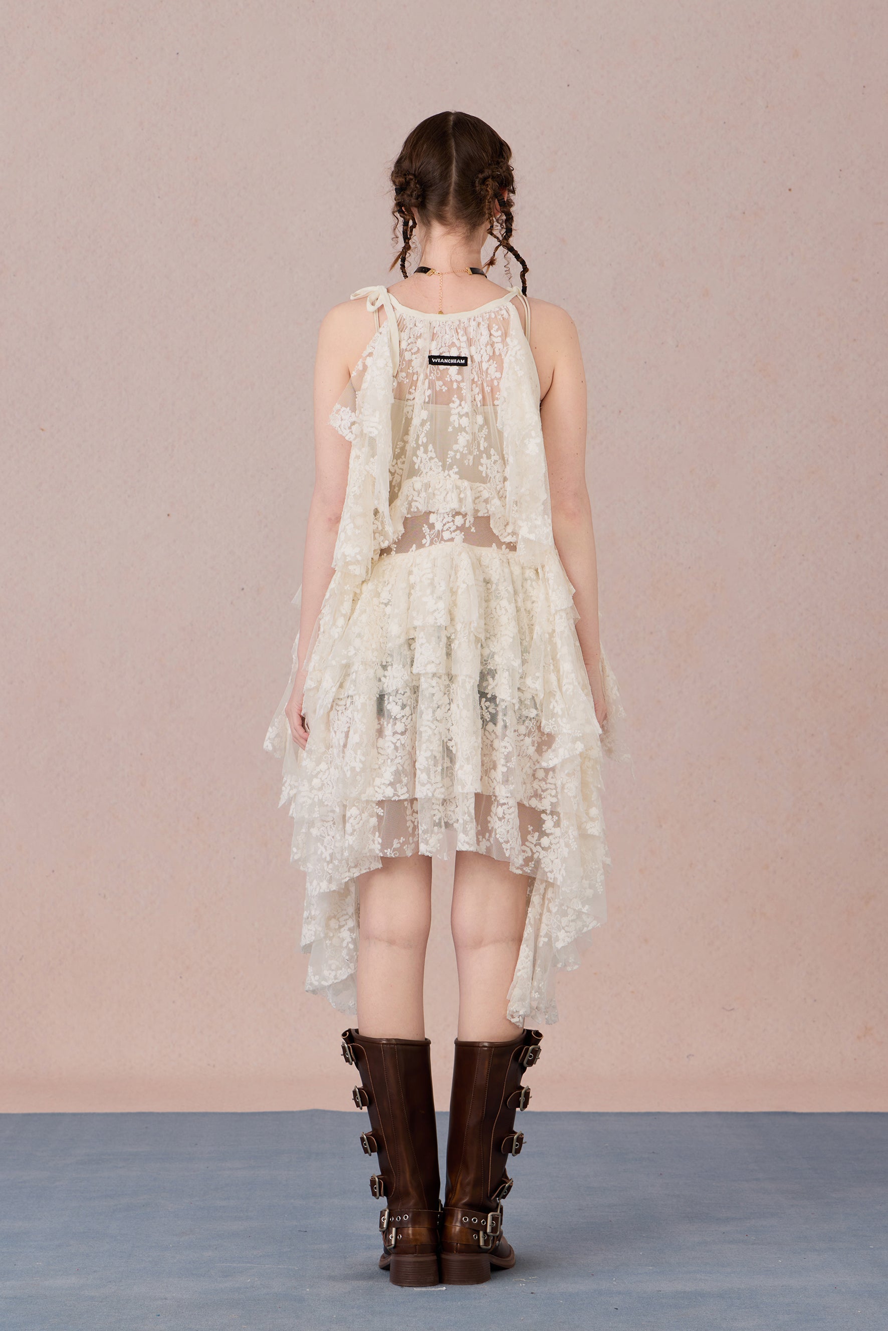 Close-up of three-dimensional beaded bow and irregular lace hem