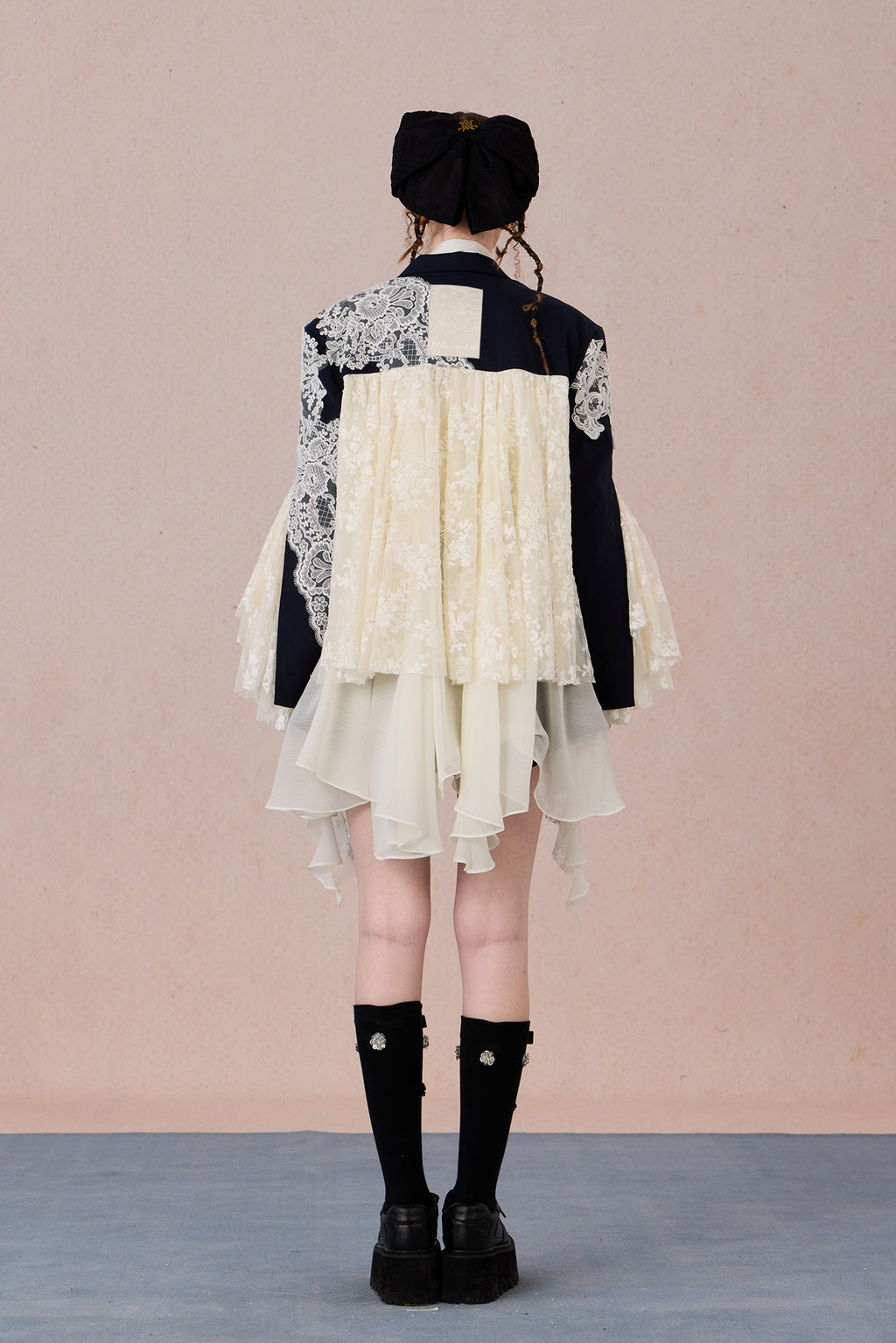 Lace collage back panel with draped asymmetry and sharp structure