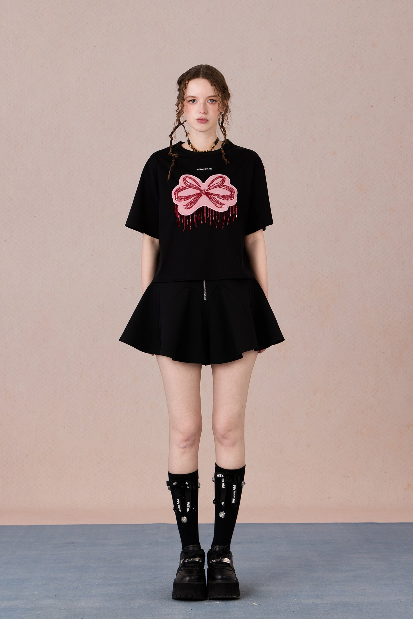 Loose fit round neck tee with bold red hand-beaded bow design