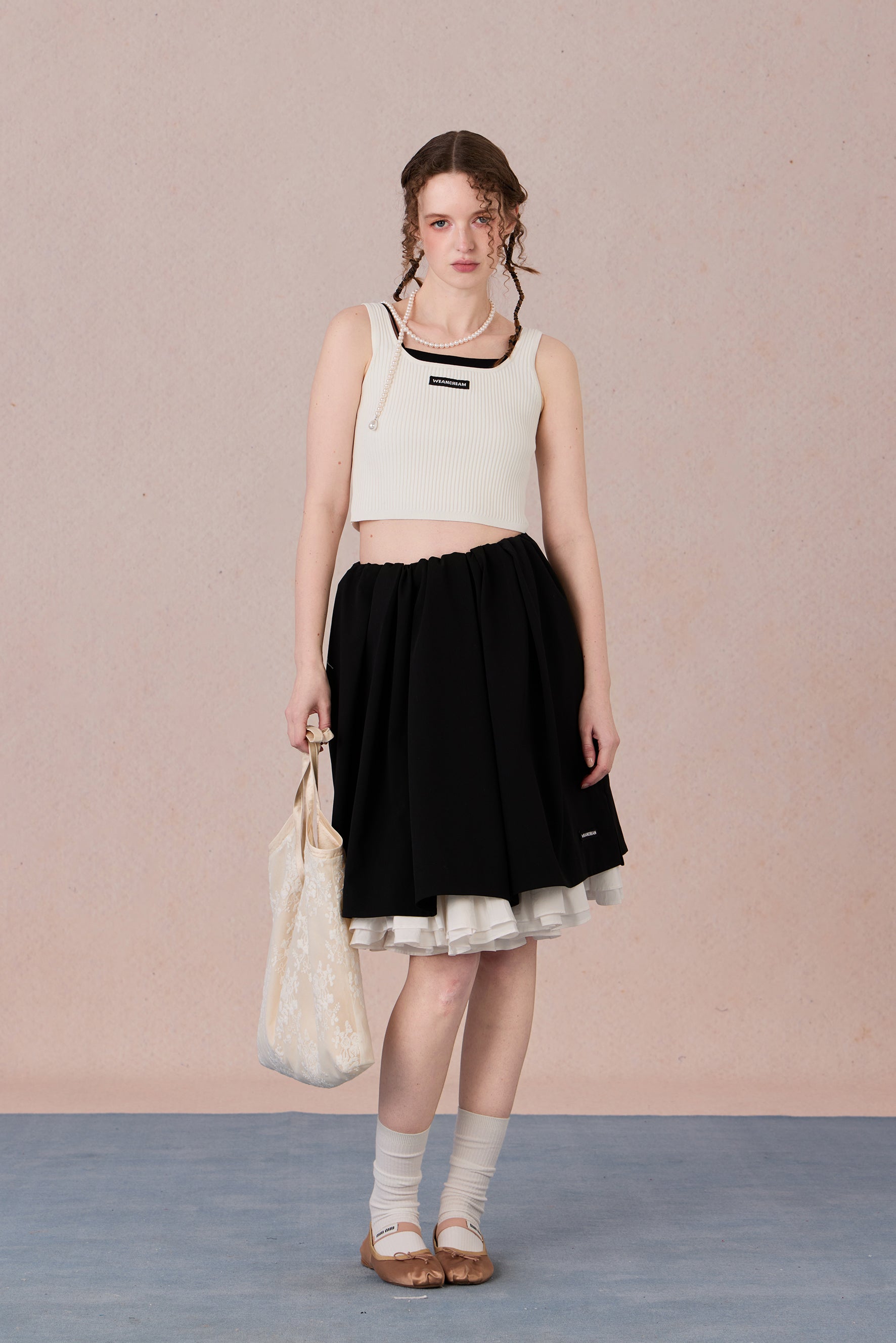 Sleeveless black and white layering-effect tank styled under a blazer